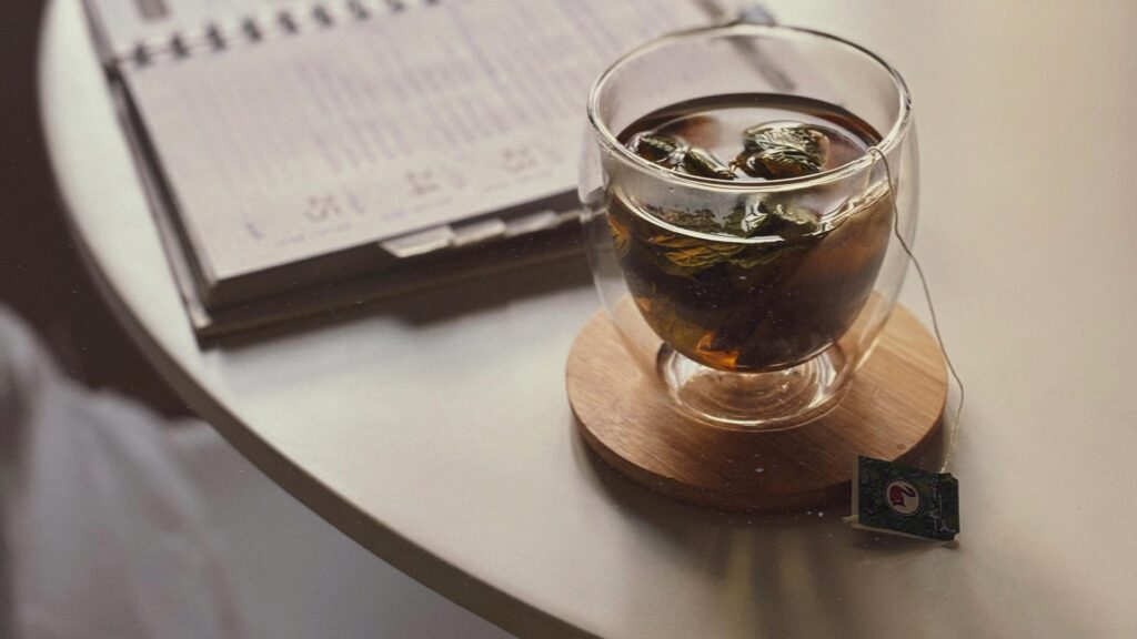 A calm desk with a notebook, plant, and cup of tea representing the contrast between a moment of panic and the steadiness that CBT for panic disorder works to restore