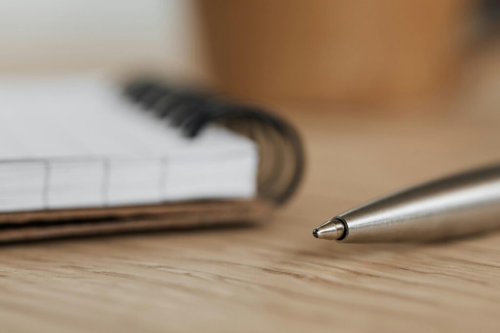 An open notebook and pen, representing the structured session work and practice assignments of online CBT for anxiety.